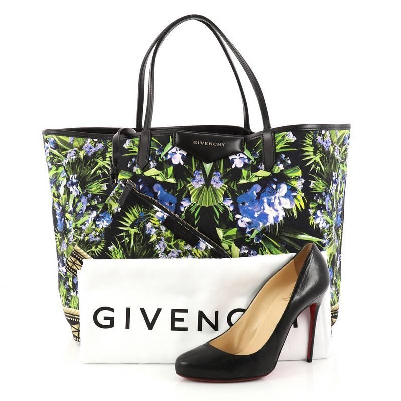 This authentic Givenchy Antigona Shopper Printed Coated Canvas Large is a statement tote made for everyday use. Crafted from green, purple and black printed floral printed coated canvas, this tote features dual slim top handles, black leather trims,