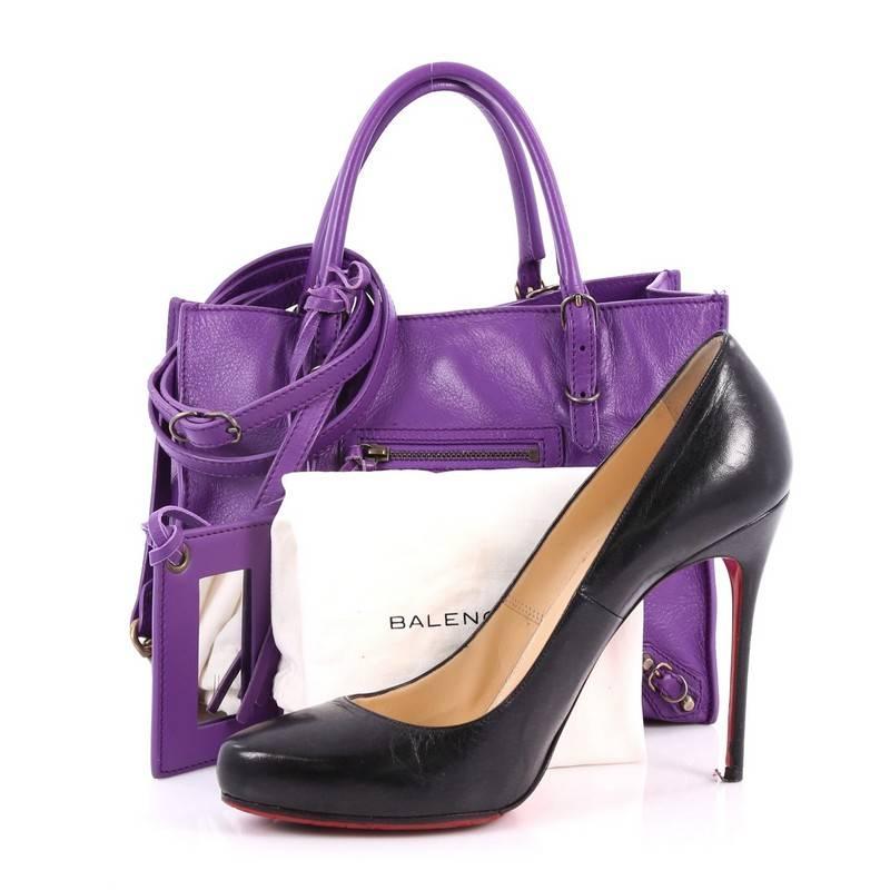 This authentic Balenciaga Papier A4 Classic Studs Handbag Leather Mini is a modern minimalist accessory that can add glam to a casual wardrobe. Crafted in purple leather, this petite boxy tote features dual-rolled slim handles, zippered sides that