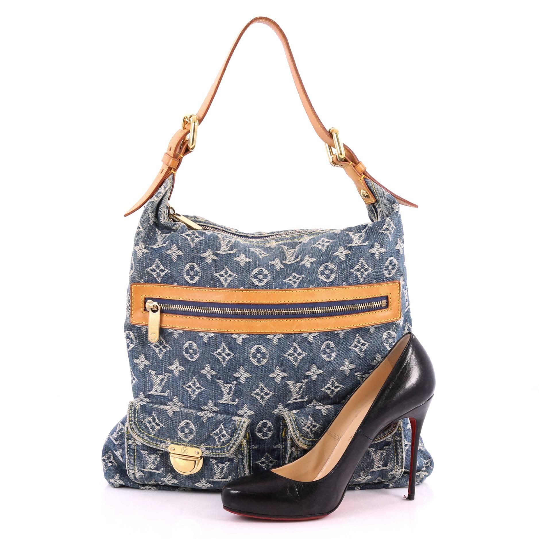 This authentic Louis Vuitton Baggy Handbag Denim GM is a fresh twist on an iconic design that will stylishly complement a casual look. Crafted from blue monogram denim, this hobo features vachetta leather trims with yellow contrast stitching, two
