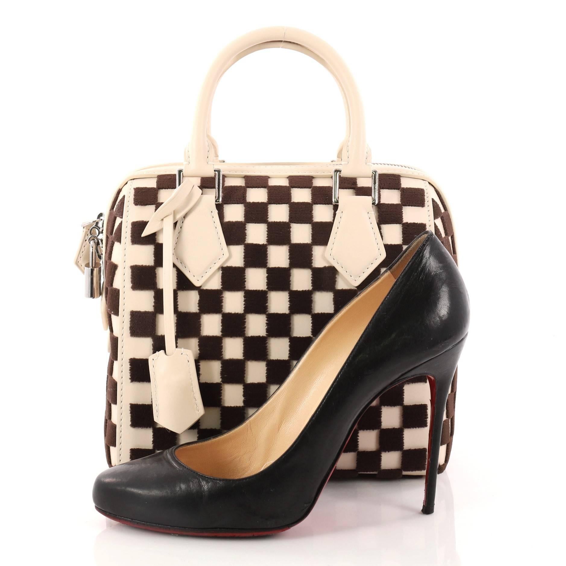 This authentic Louis Vuitton Speedy Cube Bag Damier Cubic Leather and Velvet PM is a limited edition piece showcasing the brand's classic speedy design with an edgy style. Crafted from off-white and brown damier cubic leather and velvet, this Speedy