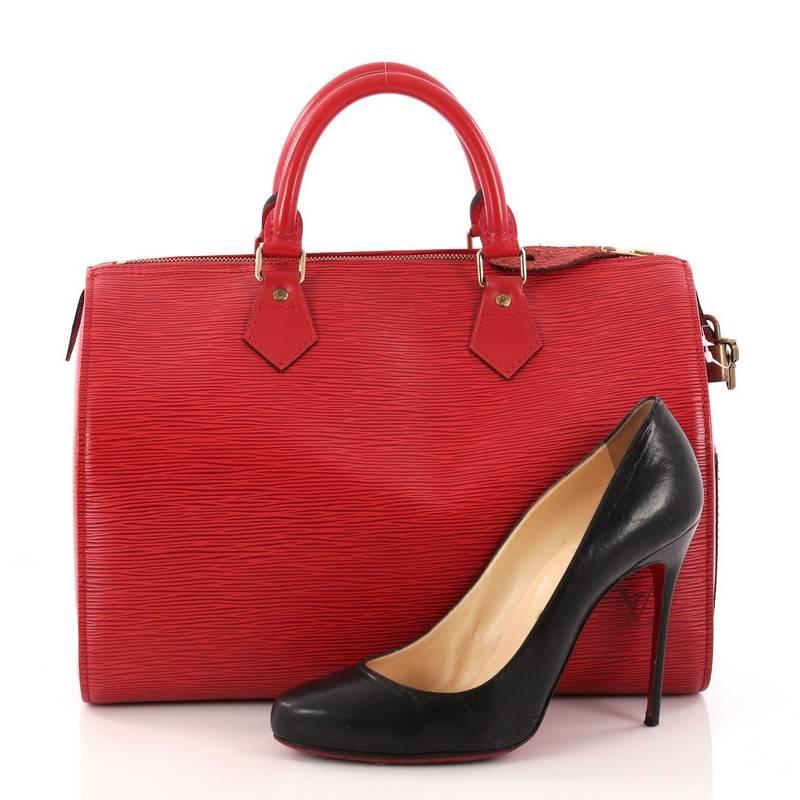 This authentic Louis Vuitton Speedy Handbag Epi Leather 30 is a fresh twist on the classic Louis Vuitton speedy design. Crafted from sturdy red epi leather, this rounded bag features dual-rolled leather handles, subtle LV logo, exterior side pocket
