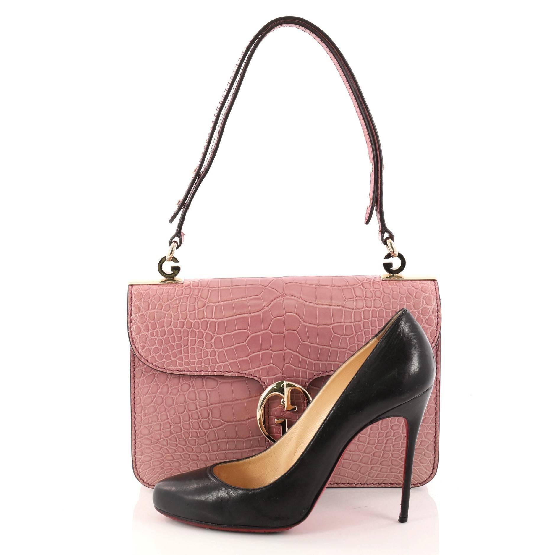 This authentic Gucci 1973 Flap Top Handle Bag Crocodile Medium is a classic for Gucci lovers. Crafted in genuine pink crocodile skin, this vintage-inspired bag features the brand's classic double G emblem detail, adjustable shoulder strap and