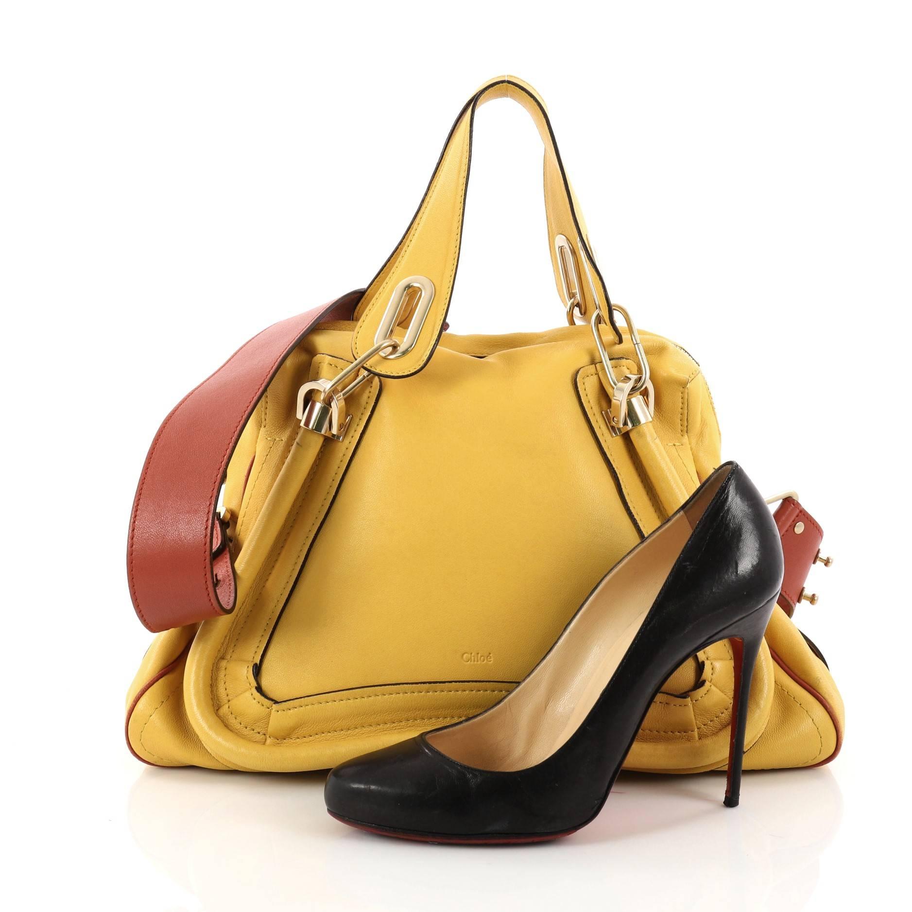 This authentic Chloe Paraty Top Handle Bag Leather Medium mixes style and functionality perfect for the modern woman. Crafted from yellow leather, this versatile satchel features piped trim details, dual handles, side twist locks, and gold-tone