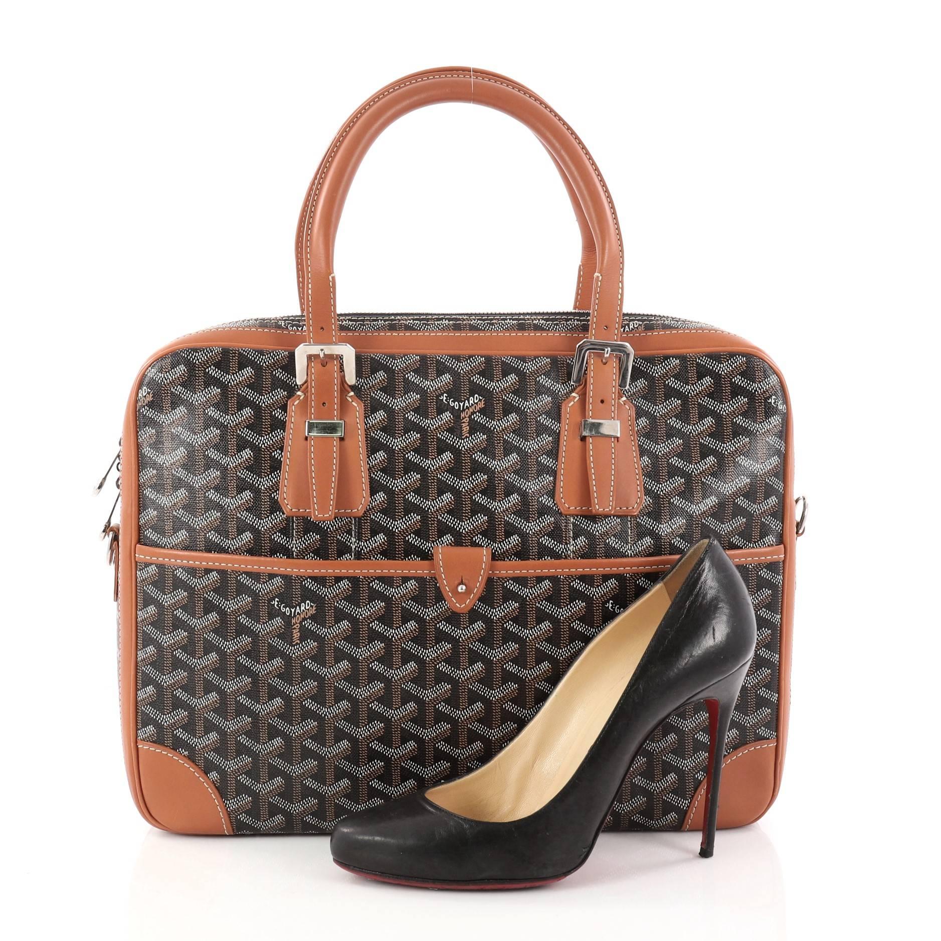 This authentic Goyard Ambassade Briefcase Coated Canvas MM is a chic and functional work-travel accessory made for stylish professionals. Crafted from black coated canvas with brown leather trims, this briefcase features dual-rolled leather handles