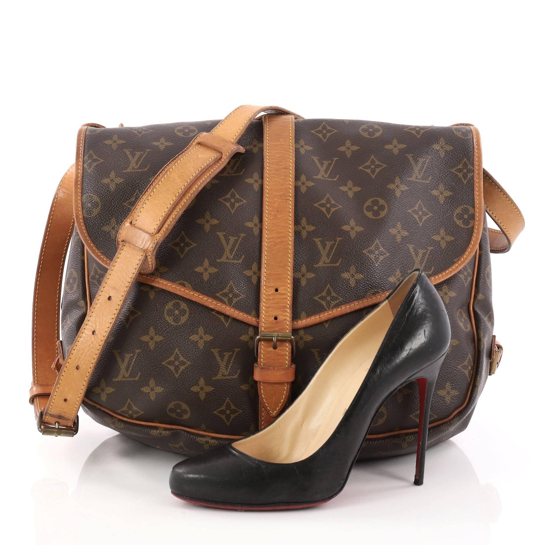 This authentic Louis Vuitton Saumur Handbag Monogram Canvas MM showcases the brand's reinterpretation of the classic saddle bag. Crafted in Louis Vuitton's popular brown monogram coated canvas, this bag features long adjustable strap, double saddle