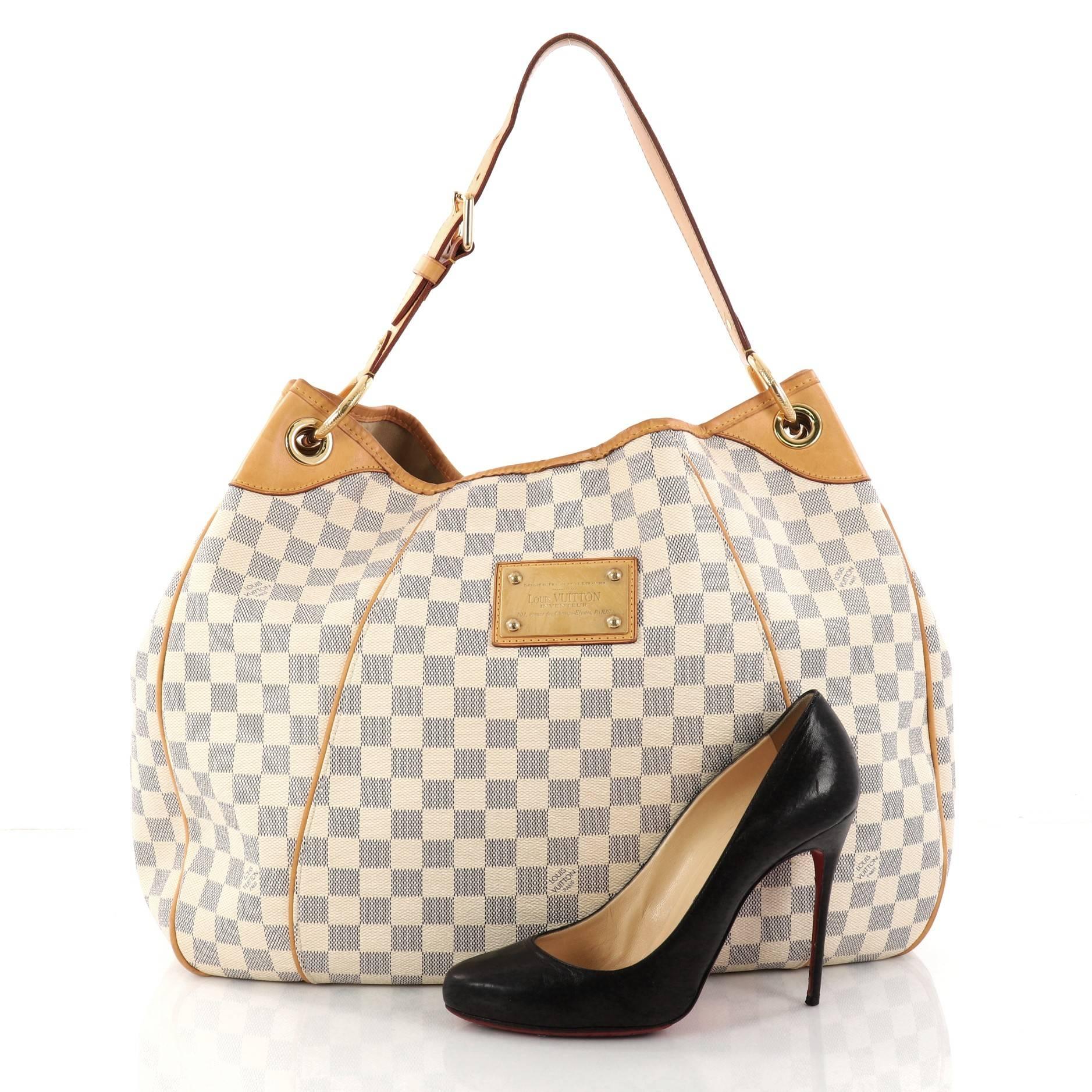 This authentic Louis Vuitton Galliera Handbag Damier GM is a bag as practical as it is iconic. Crafted from Louis Vuitton's popular damier azur coated canvas, this bag features adjustable shoulder strap, stand-out yellow contrast stitching, cowhide