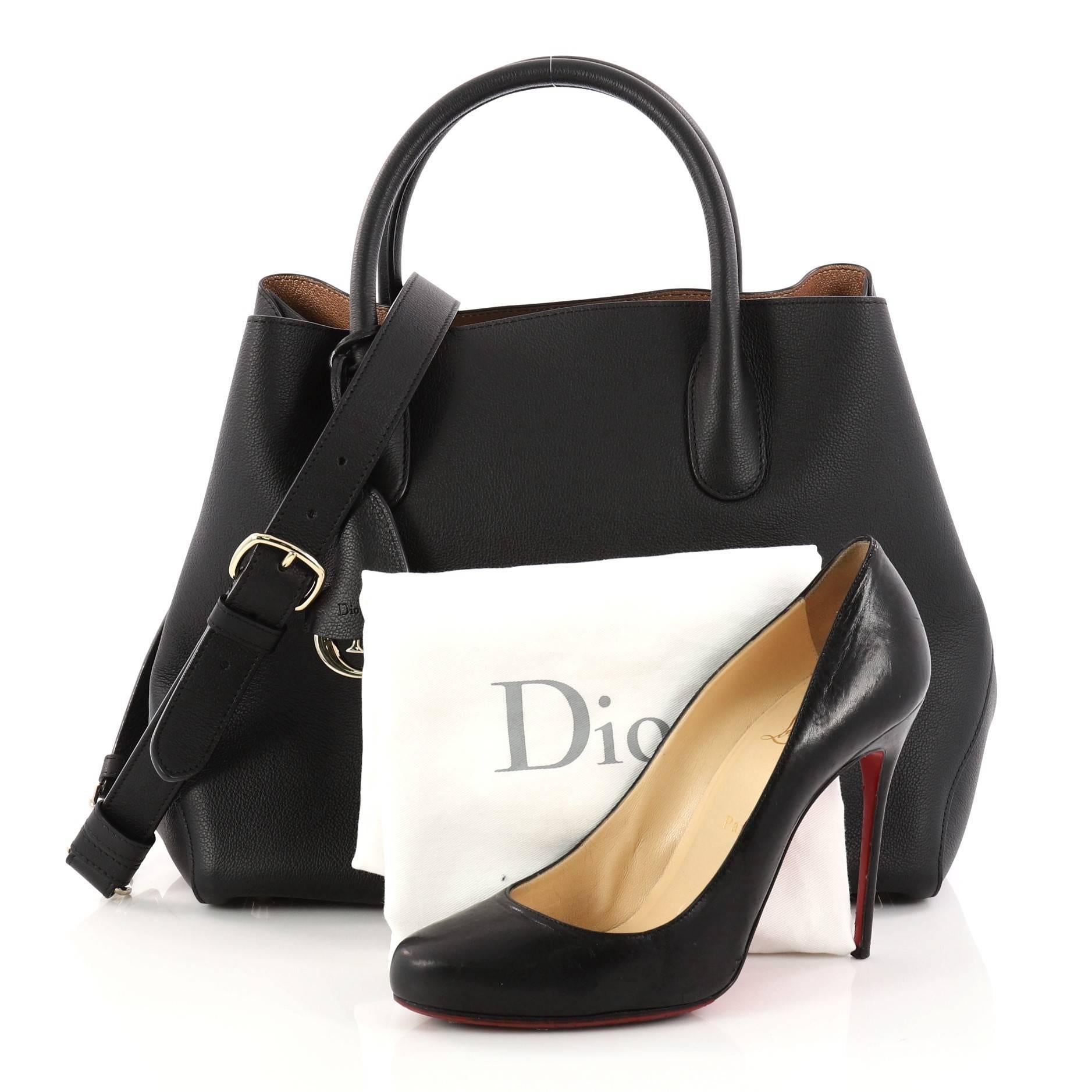 This authentic Christian Dior Open Bar Bag Leather Large takes inspiration from the brand's iconic Bar jacket. Crafted in beautiful black leather, this impeccably chic tote features a clean and soft-structured design, dual-rolled handles, protective