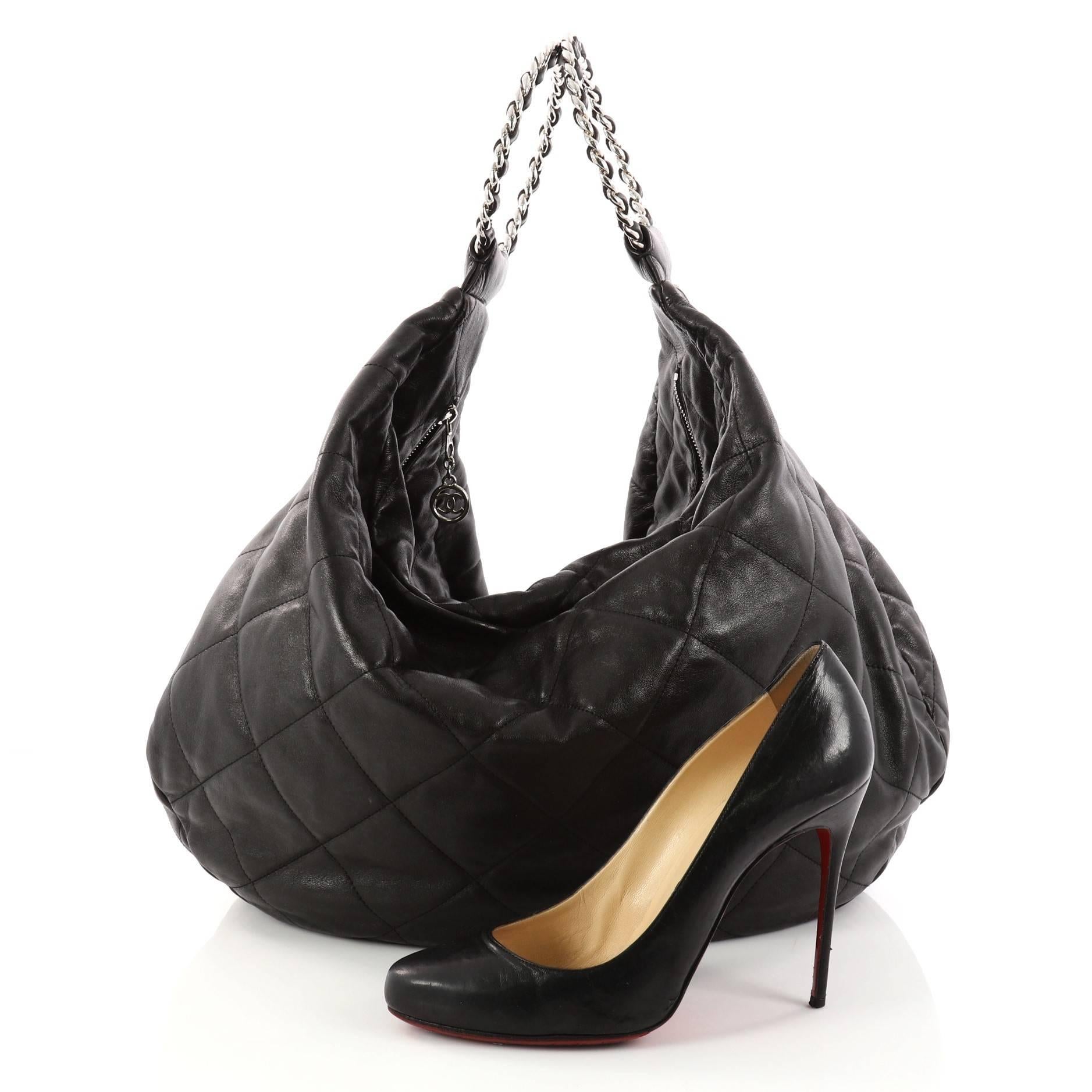 This authentic Chanel Vintage Chain Ring Handle Hobo Quilted Leather Large is the perfect carryall bag for the modern fashionista. Crafted from black quilted leather, this bag features woven-in leather chain ring handles and silver-tone hardware