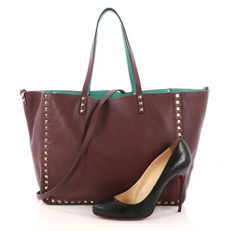 This authentic Valentino Rockstud Reversible Convertible Tote Leather Medium is perfect daily bag for any on-the-go fashionista. Crafted from burgundy and turquoise leather, this tote features the brand's iconic pyramid rockstud detailing, dual tall