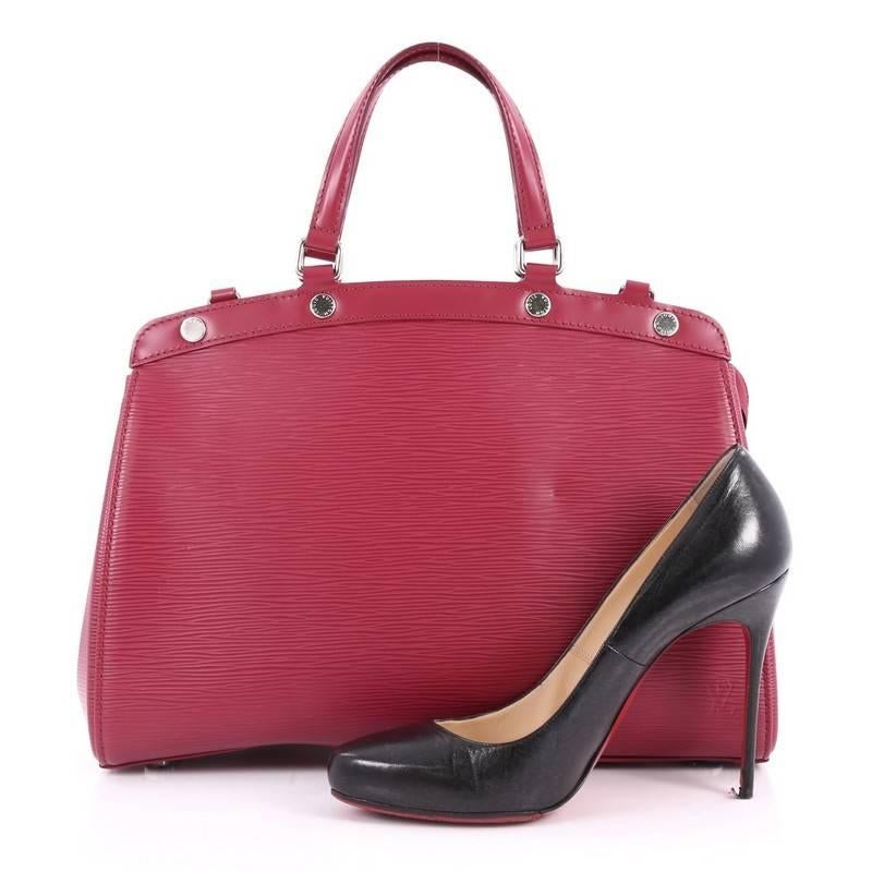This authentic Louis Vuitton Brea Handbag Epi Leather MM is a staple for an everyday casual look. Crafted from berry epi leather, this structured yet feminine tote features dual flat leather handles, engraved LV studs, subtle logo, protective base
