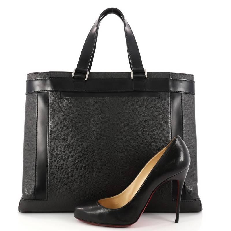 This authentic Louis Vuitton Kasbek Handbag Taiga Leather PM is a perfect bag for carrying your documents in style. crafted in black taiga leather, this tote features dual flat leather handles, exterior zip pocket and flat pocket, black leather