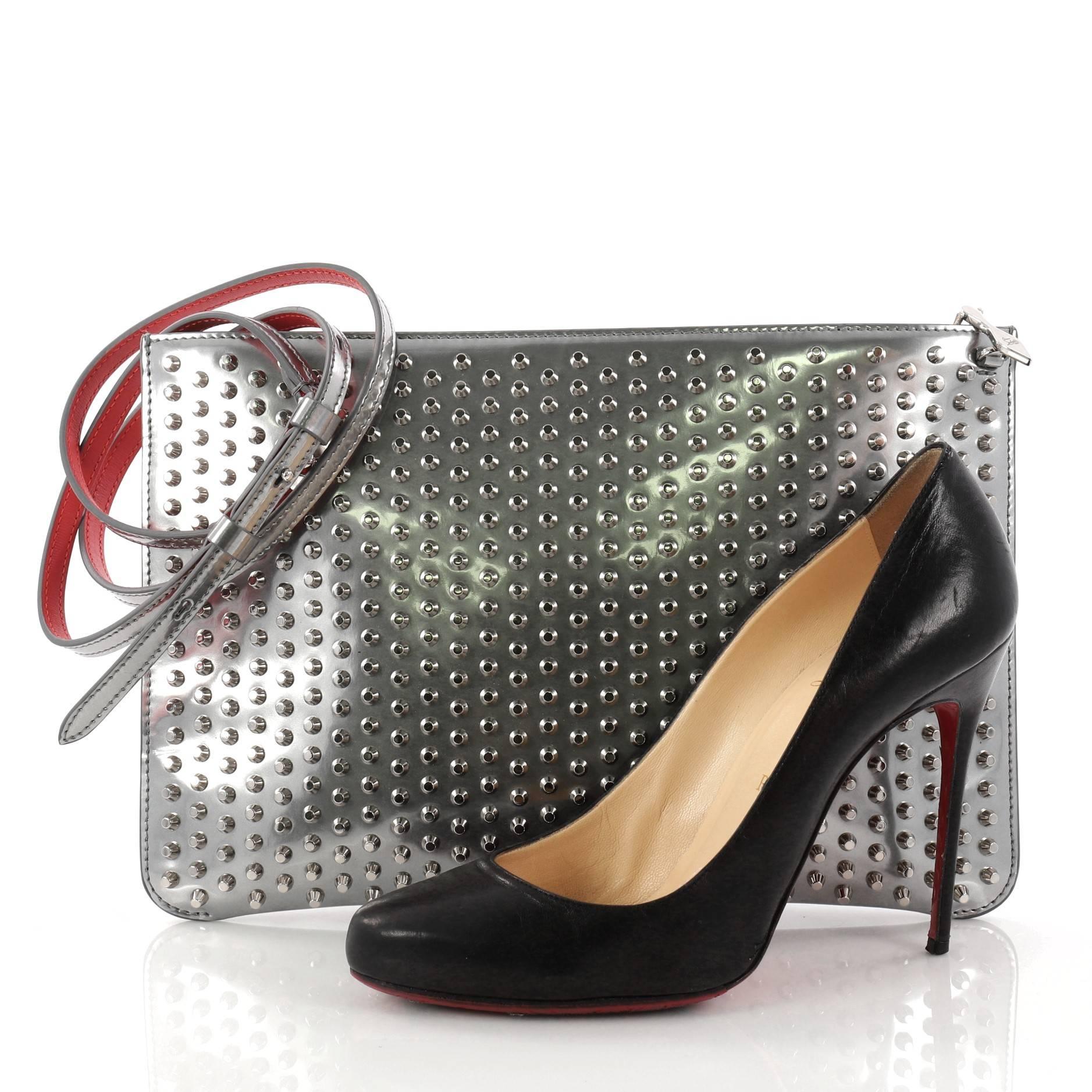 This authentic Christian Louboutin Loubiposh Clutch Spiked Patent is an edgy choice for your evening look. Crafted from silver spiked patent leather, this clutch features removable chain and leather shoulder strap, red enamel Louboutin logo zipper
