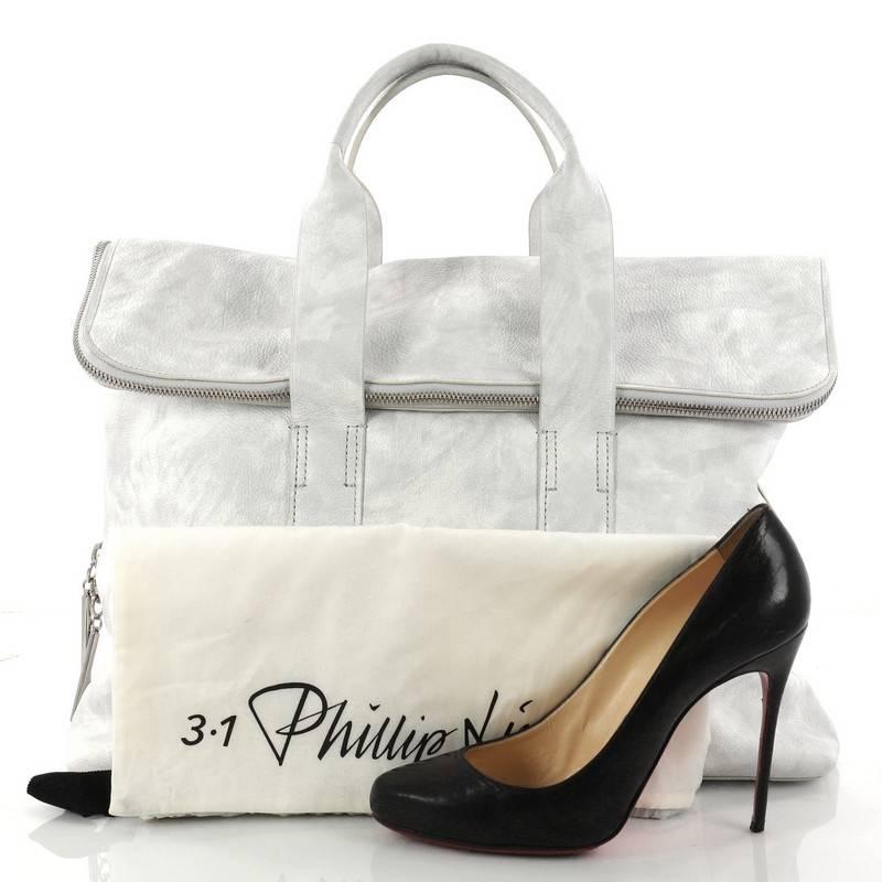 This authentic 3.1 Phillip Lim 31 Hour Fold-Over Tote Leather is a perfect minimalist everyday bag for the modern fashionista. Constructed from white and grey leather, this structured square tote features a fold over flap top that allows for