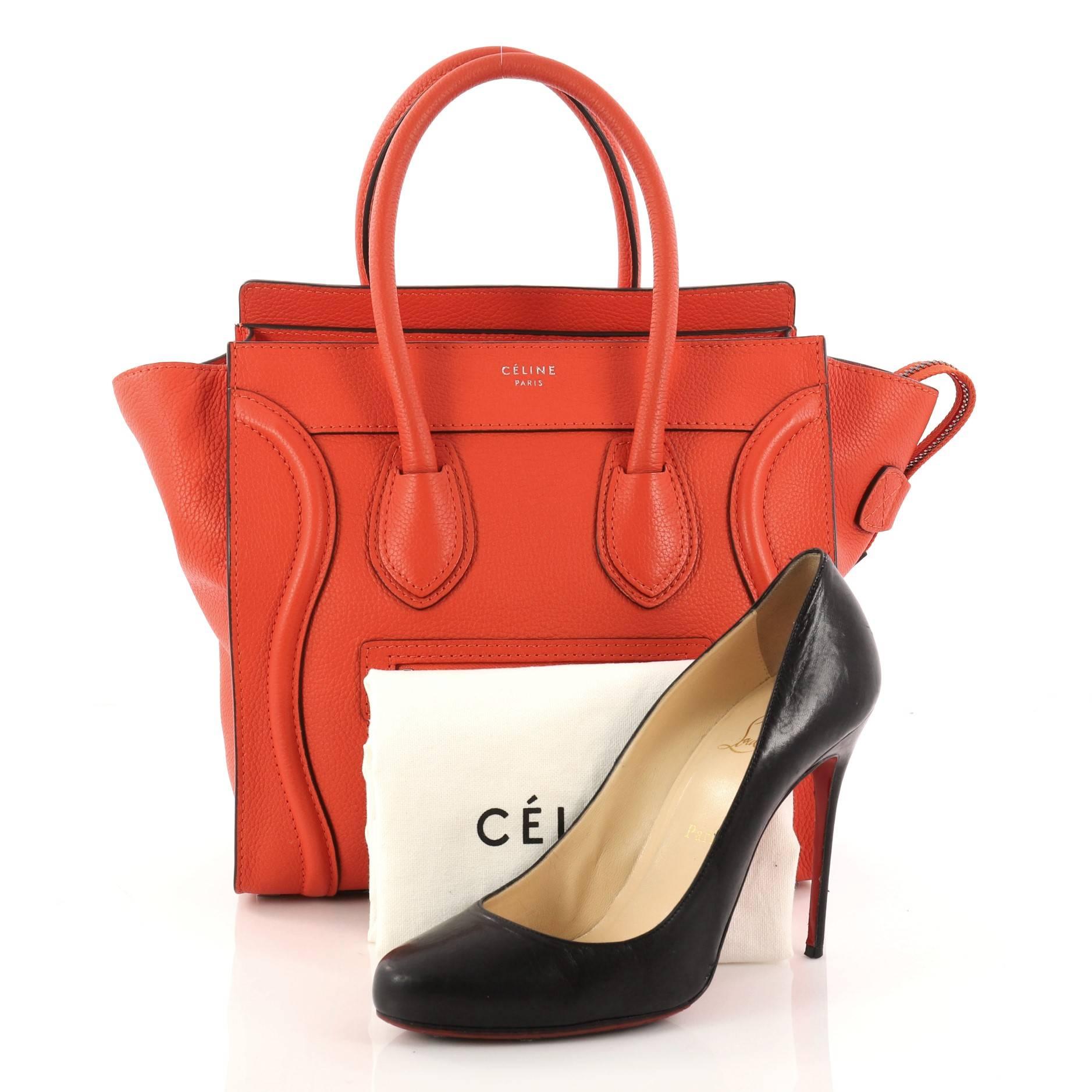 This authentic Celine Luggage Handbag Grainy Leather Micro is one of the most sought-after bags beloved by fashionistas. Crafted from orange grainy leather, this minimalist tote features dual-rolled handles, an exterior front pocket, stamped logo at