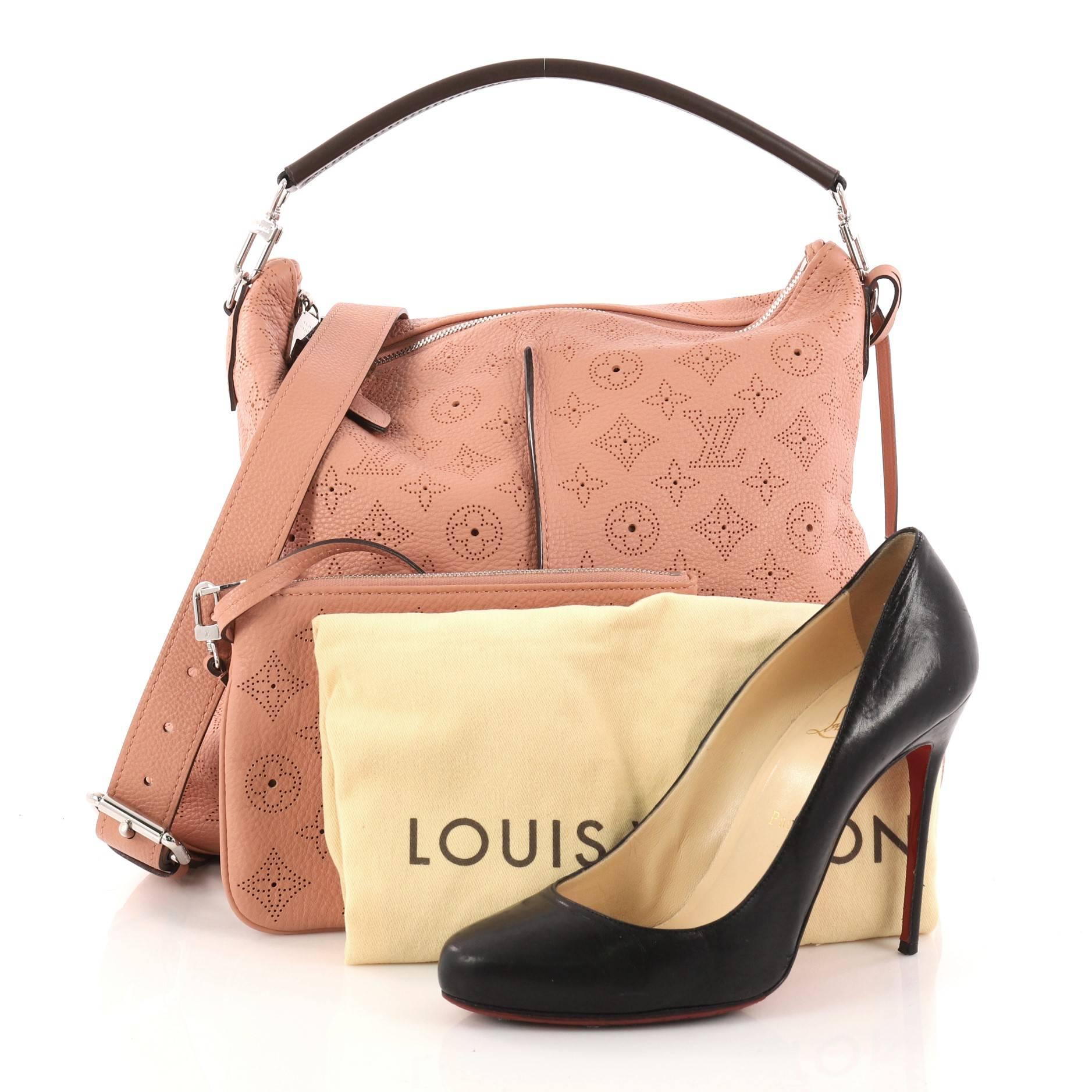 This authentic Louis Vuitton Selene Handbag Mahina Leather PM is a luxe and feminine design. Crafted in pink monogram perforated mahina leather, this beautiful hobo features a single loop leather handle, detachable leather strap, pleated detailing,