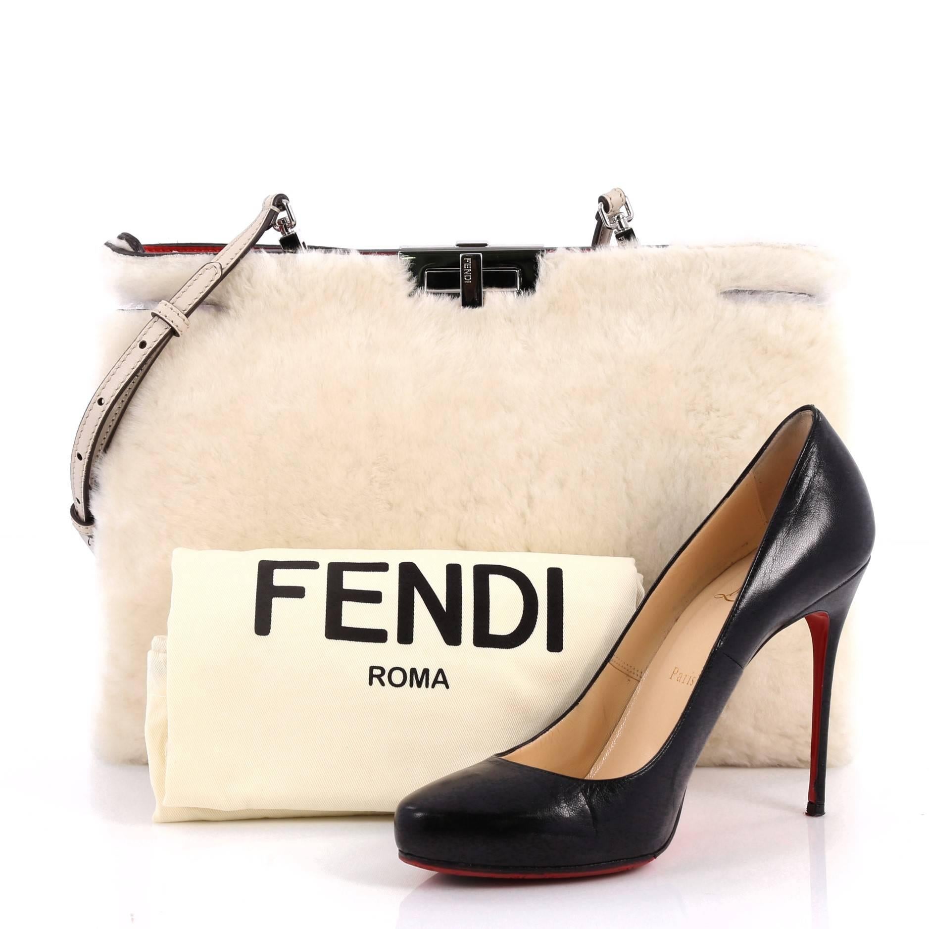 This authentic Fendi Peekaboo Clutch Bag Shearling is a chic and stylish bag perfect for your nights out. Crafted in off-white shearling, this clutch features a framed top with turn-lock closure, detachable shoulder strap, and silver-tone hardware