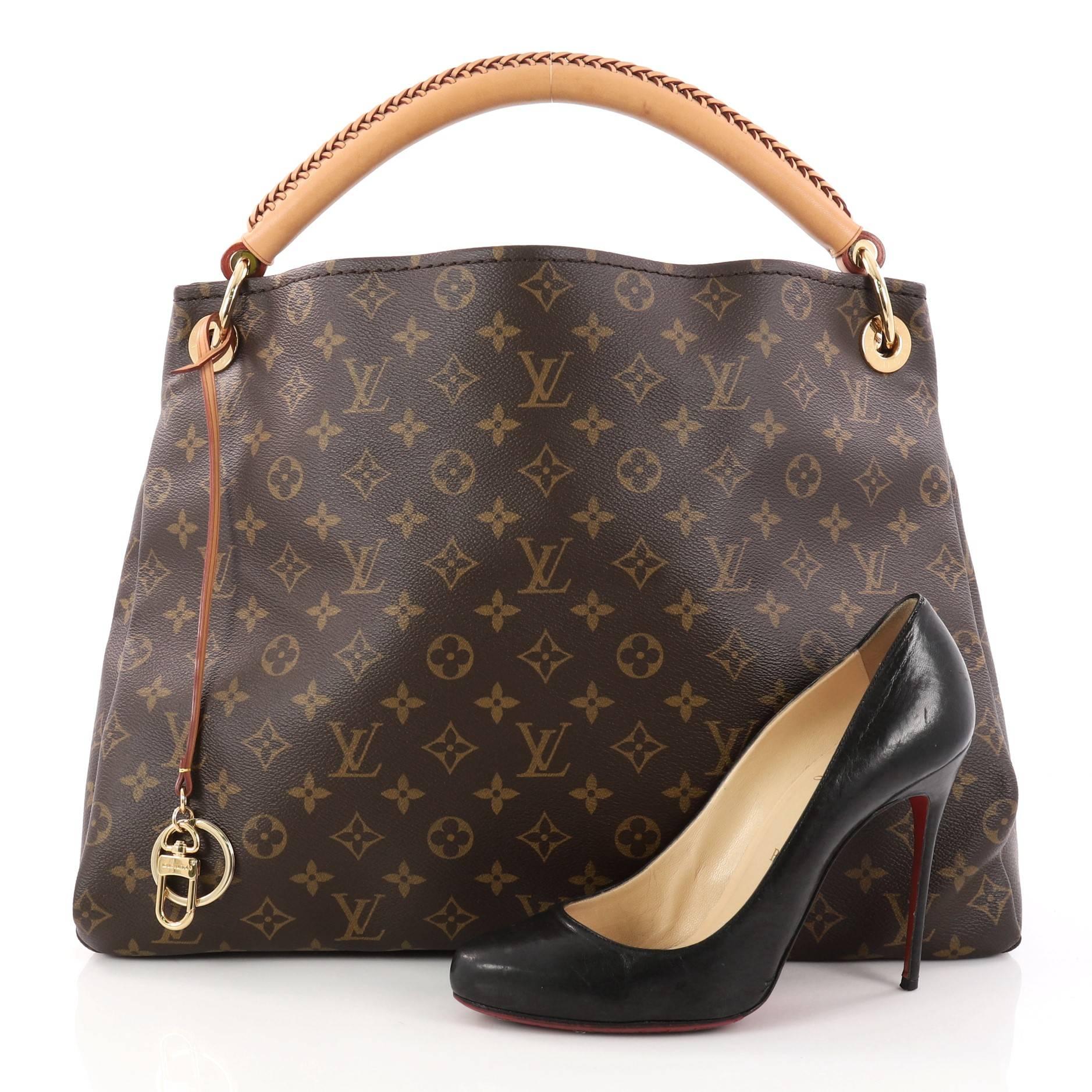This authentic Louis Vuitton Artsy Handbag Monogram Canvas MM is an elegant and iconic bag that adds a stylish flair to any outfit. Crafted from Louis Vuitton's iconic brown monogram coated canvas, this roomy Artsy hobo features a rolled leather