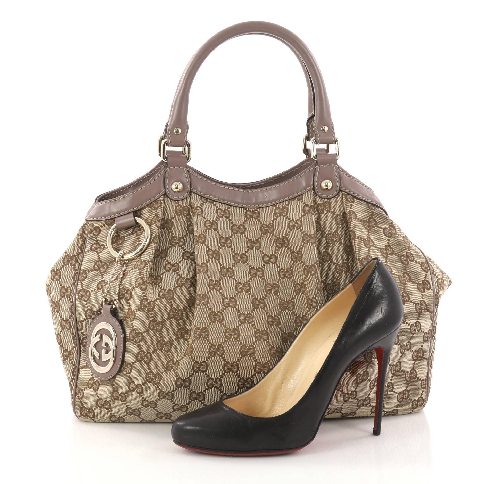 This authentic Gucci Sukey Tote GG Canvas Medium is perfect for any casual or sophisticated outfit. Constructed from Gucci's brown GG canvas with brown leather trims, this roomy tote features dual-rolled leather handles that sit comfortably on the