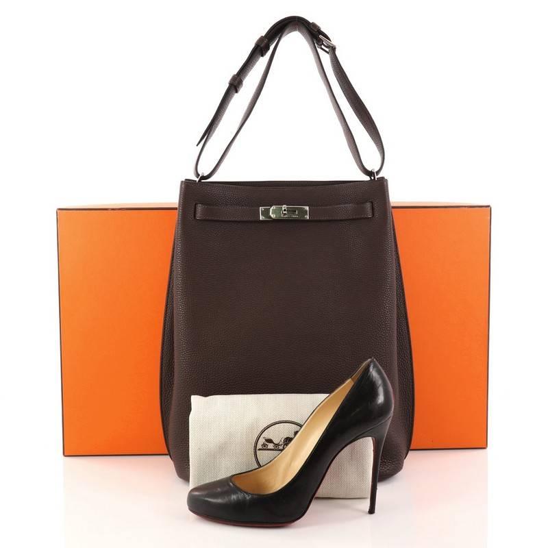 This authentic Hermes So Kelly Handbag Togo 26 is an updated and modern reinterpretation of the Kelly design. Crafted in Chocolate togo leather, this luxurious hobo features Hermes' iconic palladium turn-lock closure and an adjustable single looped