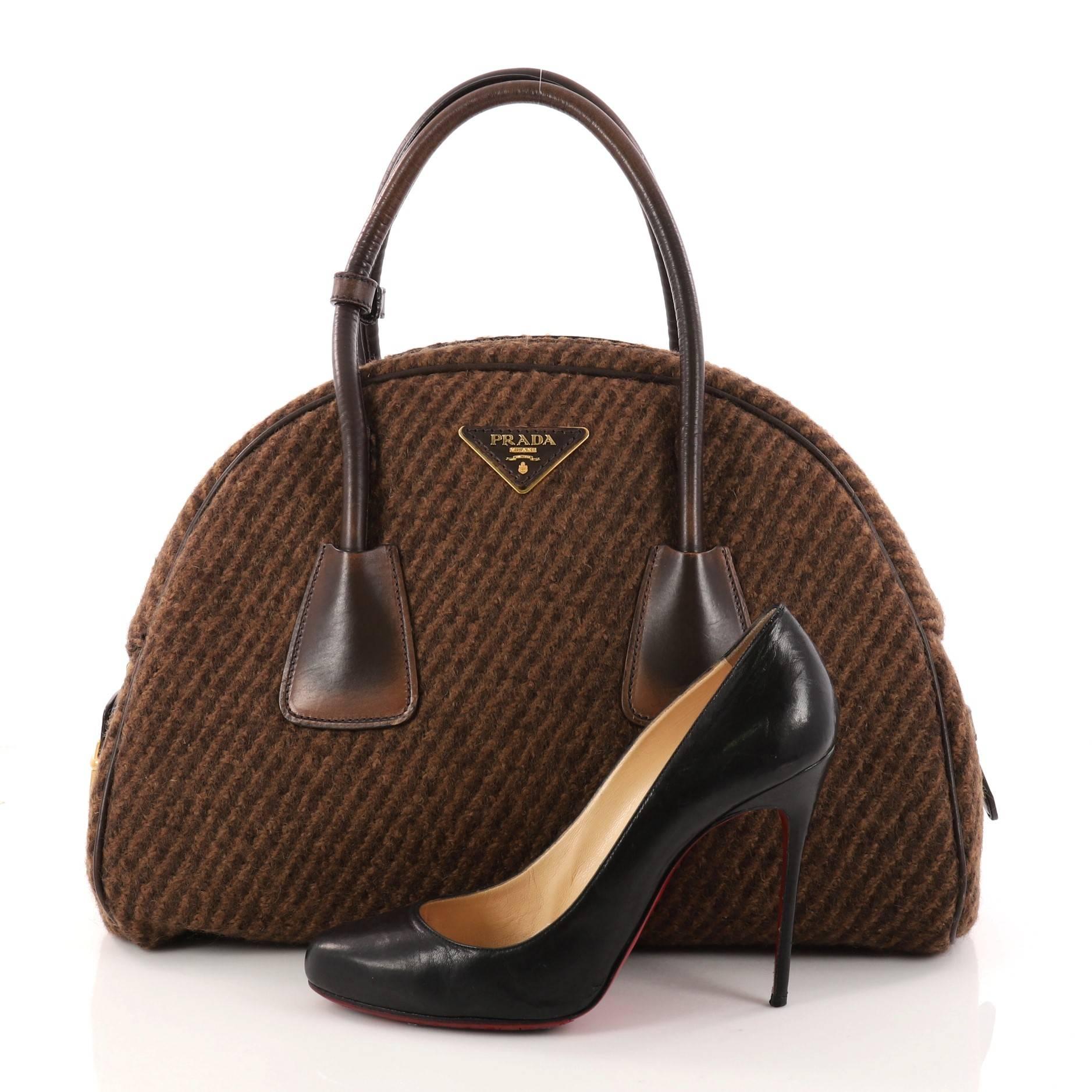 This authentic Prada Vichy Vintage Bowler Bag Tweed Large is an elegant eye-catching accessory made for every fashionista. Crafted from brown tweed, this bag features stained dual-rolled handles, triangular Prada logo at top center, protective base