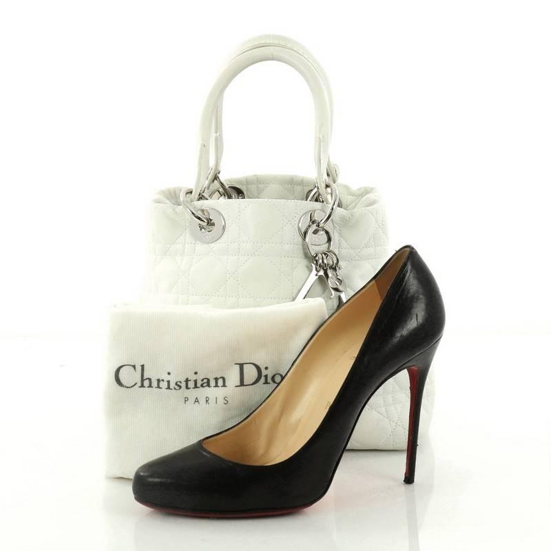This authentic Christian Dior Lady Dior Soft Tote Cannage Quilt Lambskin Medium is a classic staple that every fashionista needs in her wardrobe. Crafted from white lambskin leather with Dior's iconic cannage stitching, this easy-chic bag features
