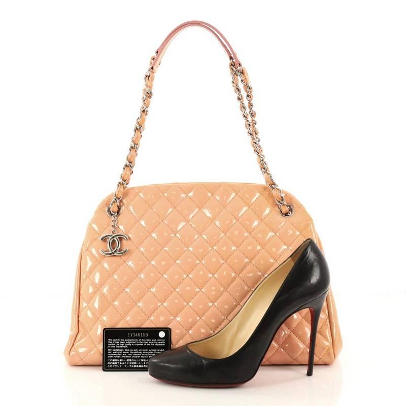 This authentic Chanel Just Mademoiselle Handbag Quilted Patent Large complements any look. Crafted from light peach quilted patent leather in Chanel's iconic diamond stitch pattern, this timeless bag features woven-in leather chain straps with