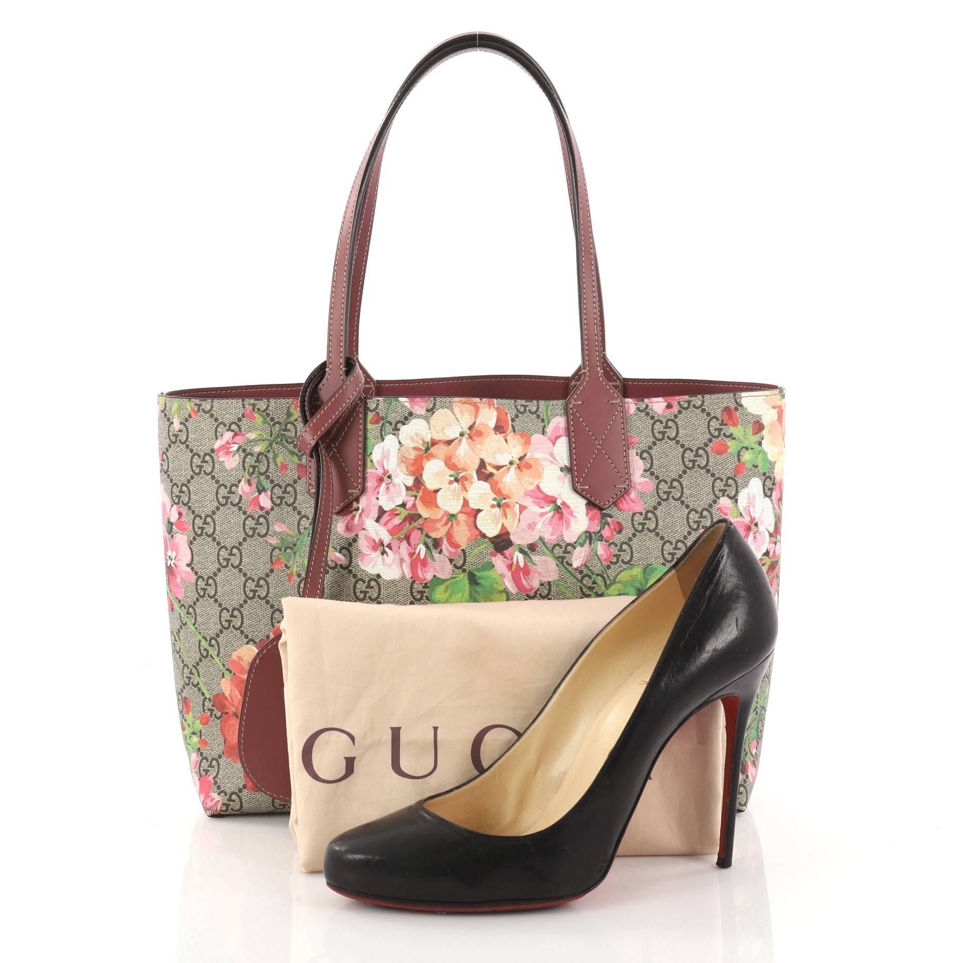 This authentic Gucci Reversible Gucci Reversible Tote Blooms GG Print Leather Small is perfect for everyday casual looks. Crafted in brown GG blooms print leather and dark mauve leather on its reverse side with contrast beige stitching, this simple