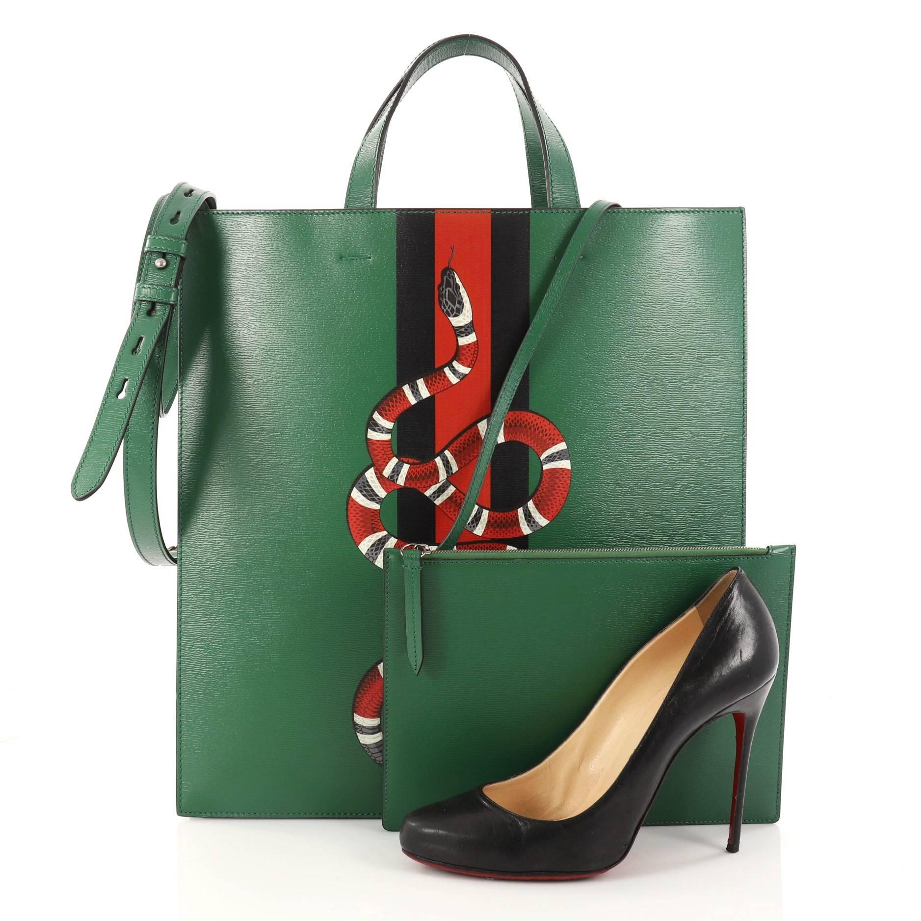 This authentic Gucci Web and Snake Convertible Soft Open Tote Printed Leather Tall is a stylish bag designed to be worn multiple ways. Crafted in green leather, this chic bag features two iconic Gucci motifs: the House Web in green/red and the