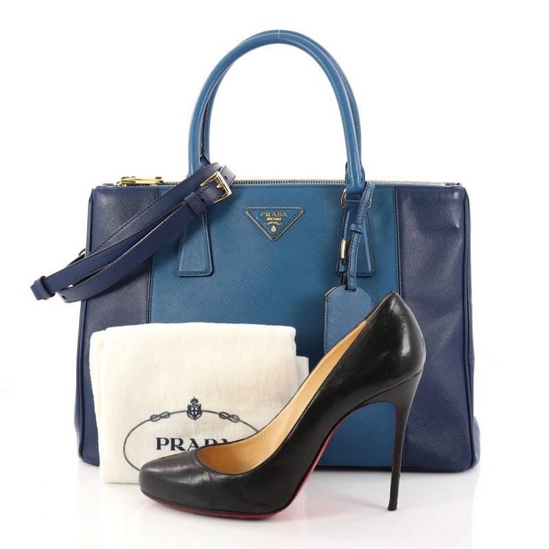 This authentic Prada Bicolor Double Zip Lux Tote Saffiano Leather Medium is the perfect bag to complete any simple outfit. Crafted in bicolor blue saffiano leather, this elegant and chic bag features side snap buttons, raised Prada logo, protective