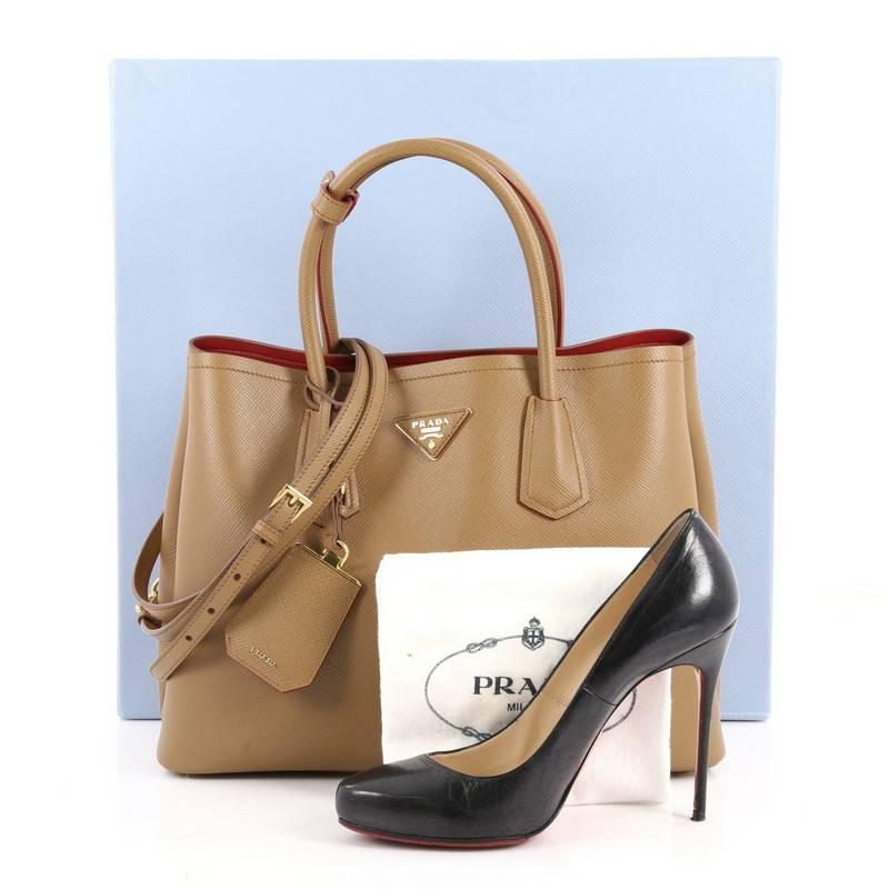 This authentic Prada Cuir Double Tote Saffiano Leather Small is a modern tote with great functionality. Crafted from brown saffiano leather, this luxurious tote features dual-rolled top handles, side snap buttons, Prada's trademark triangle logo at