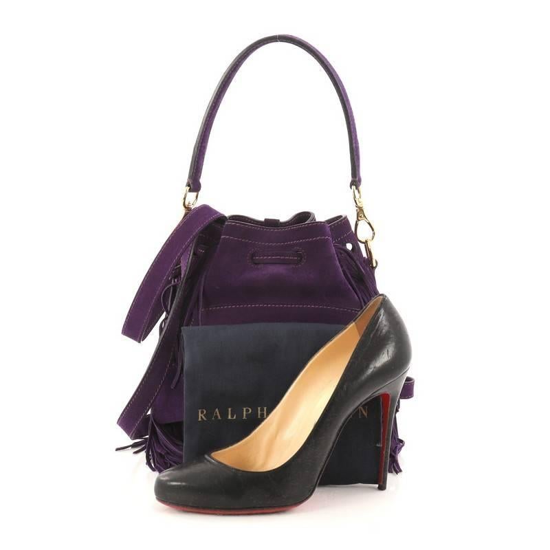 This authentic Ralph Lauren Collection Ricky Drawstring Bag Fringe Suede Small is a reinvention of the brand's most loved Ricky collection. Crafted from purple suede, this petite, stylish bucket bag features an exterior front flap pocket with