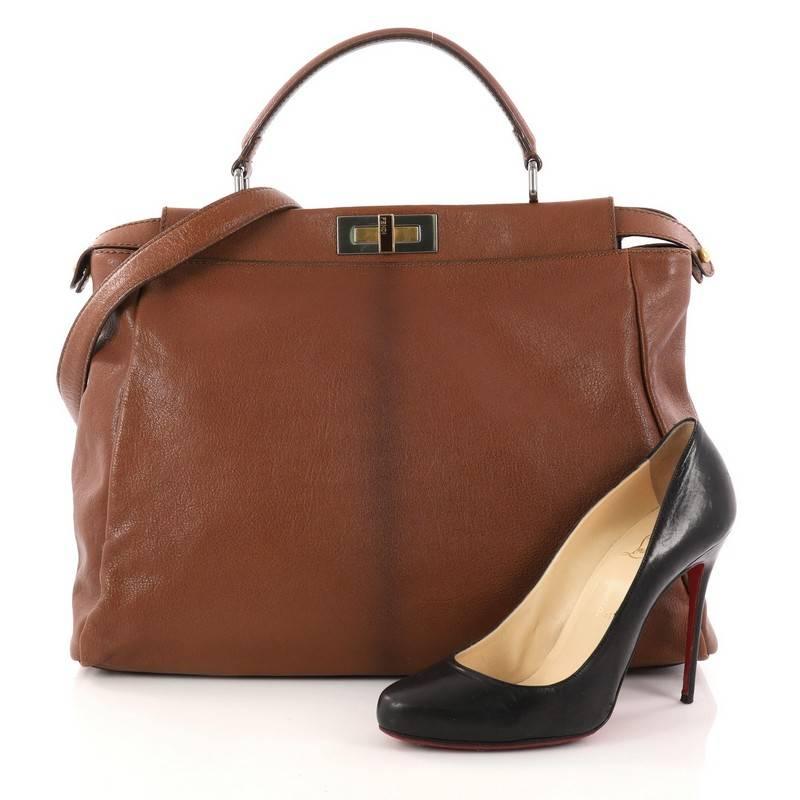 This authentic Fendi Peekaboo Handbag Leather Large is one of Fendi's best-known designs exuding a luxurious yet minimalist appearance. Crafted in brown leather, this versatile and stylish satchel features a flat leather top handle, protective base