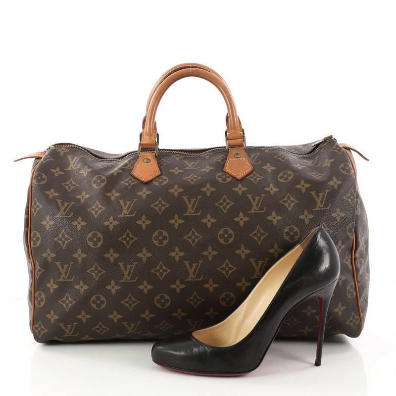 This authentic Louis Vuitton Speedy Handbag Monogram Canvas 40 is spacious and light, making it ideal to use every day. Constructed in Louis Vuitton's classic brown monogram coated canvas, this iconic Speedy features dual-rolled leather handles,