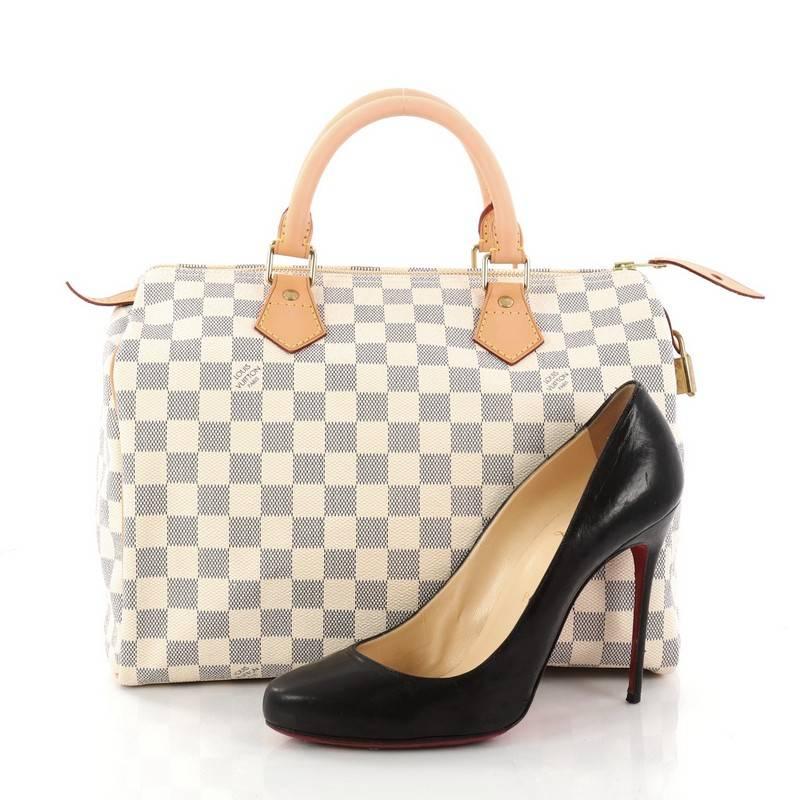This authentic Louis Vuitton Speedy Handbag Damier 30 is a timeless favorite of many. Constructed from Louis Vuitton's signature damier azur coated canvas, this iconic Speedy features dual-rolled handles, vachetta leather trims and gold-tone