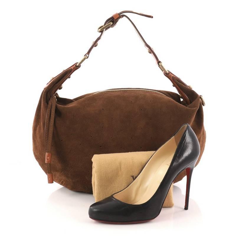 This authentic Louis Vuitton Onatah Hobo Suede GM is a limited edition bag that is both stylish and functional. Crafted from brown monogram perforated suede, this bag features an adjustable polyester striped handle with cowhide trim, slouchy