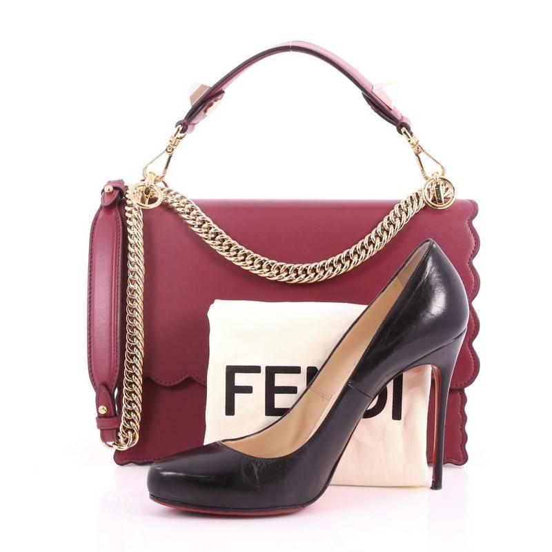 This authentic Fendi Kan I Handbag Leather Medium is a uniquely designed bag perfect for the stylish fashionista. Crafted from magenta leather with scalloped trims, this bag features lat top handle with ABS studs, long sliding chain-link shoulder