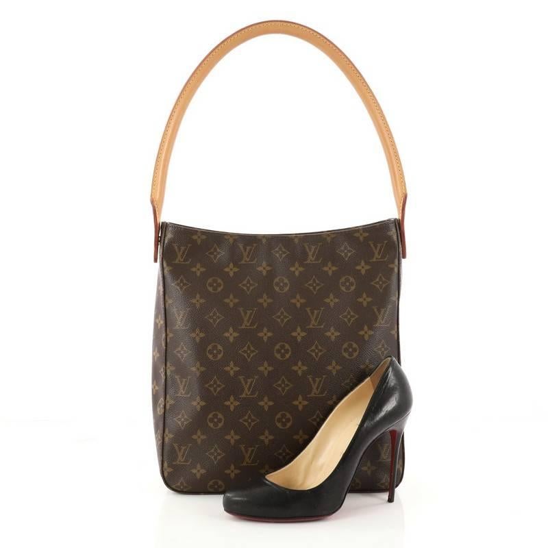 This authentic Louis Vuitton Looping Handbag Monogram Canvas GM is a sturdy bag that has a unique and modern structure perfect for day or night. Crafted from brown monogram coated canvas, this bag features an arched natural vachetta leather handle