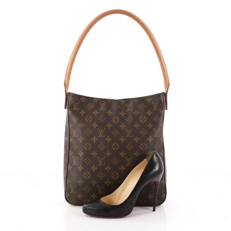 This authentic Louis Vuitton Looping Handbag Monogram Canvas GM is a sturdy bag that has a unique and modern structure perfect for day or night. Crafted from brown monogram coated canvas, this bag features an arched natural vachetta leather handle