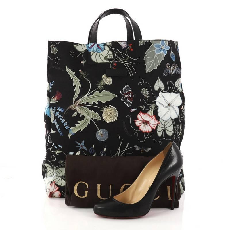 This authentic Gucci G-Active Knight Tote Flora Canvas Tall is a perfect tote for everyday use. Crafted in black flora canvas, this stylish tote features dual flat leather handles and beige-tone hardware accents. Its wide open top showcases an