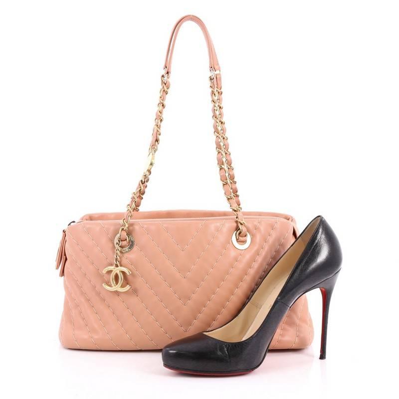 This authentic Chanel Surpique CC Charm Tote Chevron Lambskin Small combines casual luxe style with understated functionality perfect for daily excursions. Crafted from pink chevron iridescent calfskin leather, this chic shoulder bag features dual