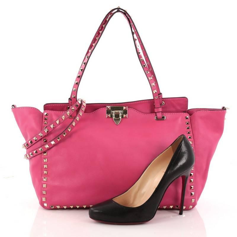 This authentic Valentino Rockstud Tote Soft Leather Medium mixes edgy style with luxurious detailing. Crafted from pink soft leather, this stylish tote features dual tall flat handles, gold-tone pyramid stud trim details, signature clasp lock, stamp