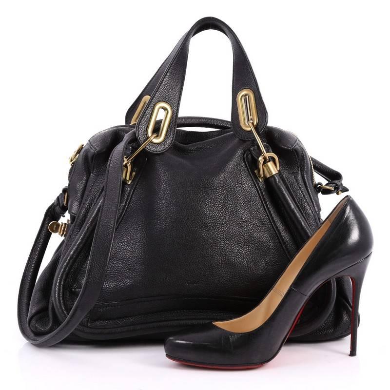 This authentic Chloe Paraty Top Handle Bag Leather Medium mixes everyday style and functionality perfect for the modern woman. Crafted from black leather, this versatile bag features dual flat handles, piped trim details, side twist locks, and