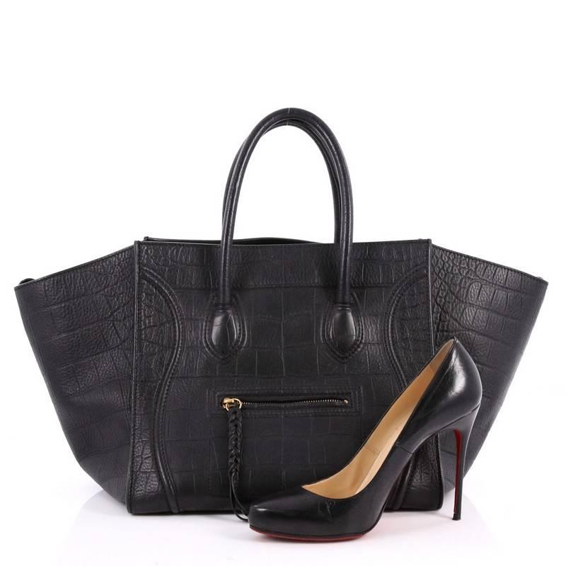 This authentic Celine Phantom Handbag Crocodile Embossed Leather Medium is one of the most sought-after bags beloved by fashionistas. Crafted from black crocodile embossed leather, this minimalist tote features dual-rolled handles, an exterior front