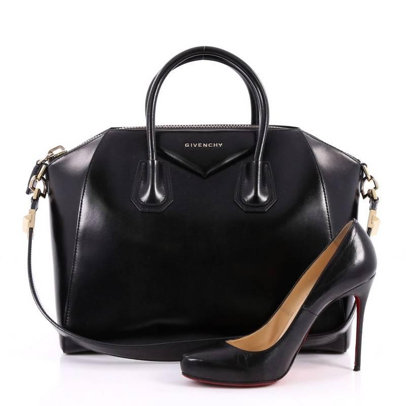 This authentic Givenchy Antigona Bag Glazed Leather Medium combines style and functionality all-in-one. Crafted from sleek, black glazed leather, this structured handle bag features dual-rolled leather handle, brand's signature envelope flap detail