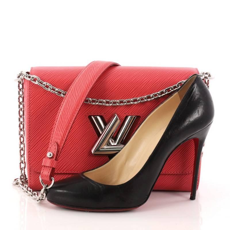 This authentic Louis Vuitton Twist Handbag Epi Leather MM is a coveted piece exuding a luxurious design with contemporary flair. Crafted in pink epi leather, this chic bag features a waved base silhouette, silver chain link strap with leather pad,