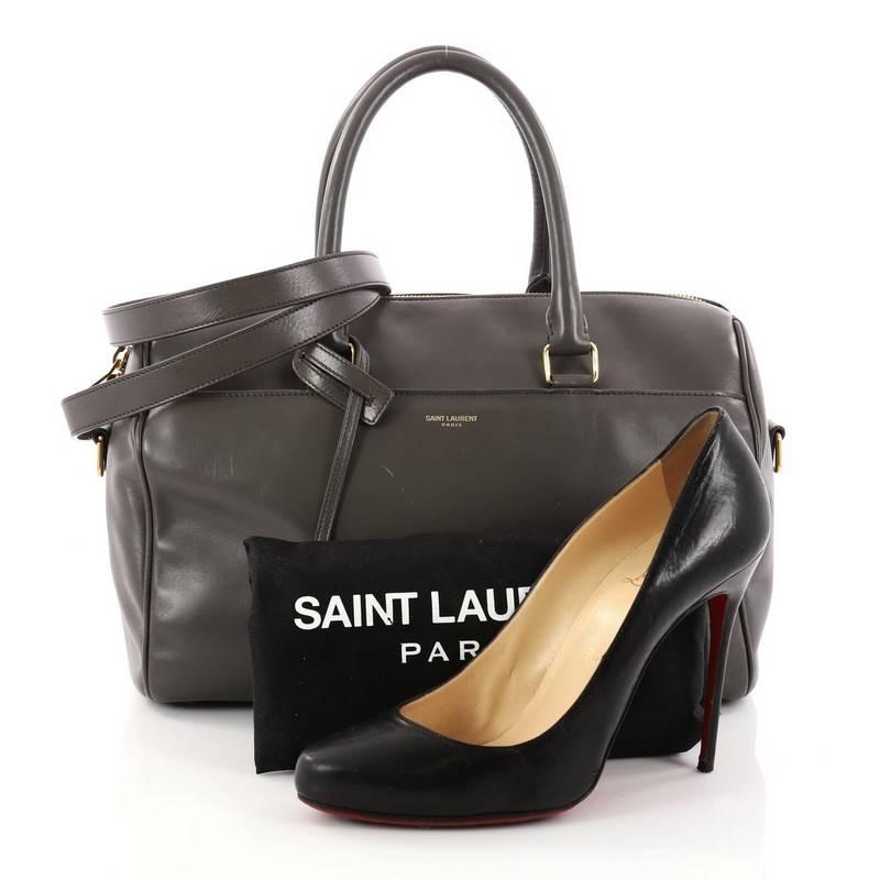 This authentic Saint Laurent Classic Duffle Bag Leather 6 is a modern and elegant duffle bag to travel with. Crafted in grey leather, this alluring bag features dual-rolled leather handles, stamped Saint Laurent logo at the front, protective base