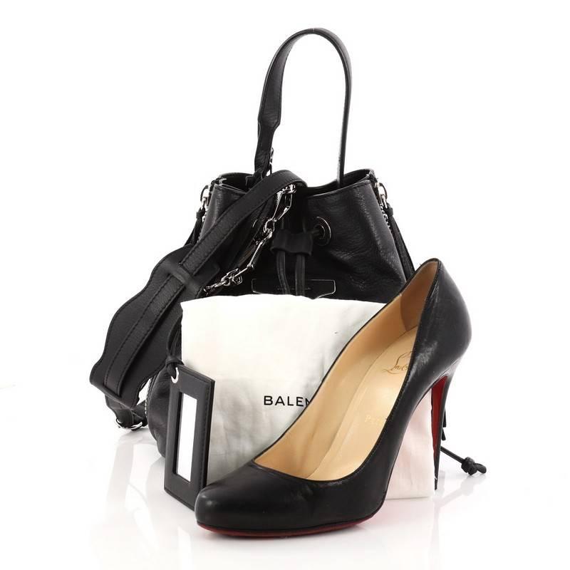 This authentic Balenciaga Papier Plate Bucket Bag Leather XS is one of the cutest pieces you can ever own and add to your bag collection. Crafted from black leather, this petite bag features removable buckled adjustable shoulder strap, expandable