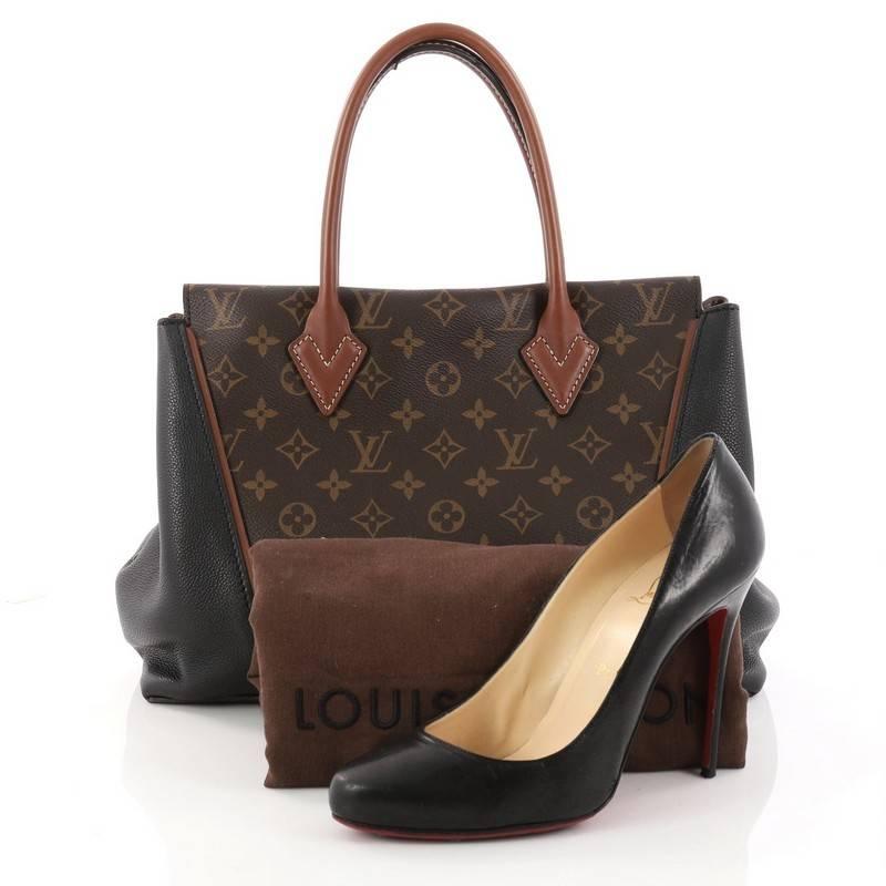 This authentic Louis Vuitton W Tote Monogram Canvas and Leather PM is a collector's dream, a fresh and youthful design made for the modern woman. Crafted in iconic brown monogram canvas with noir black calfskin leather sides, this luxurious and