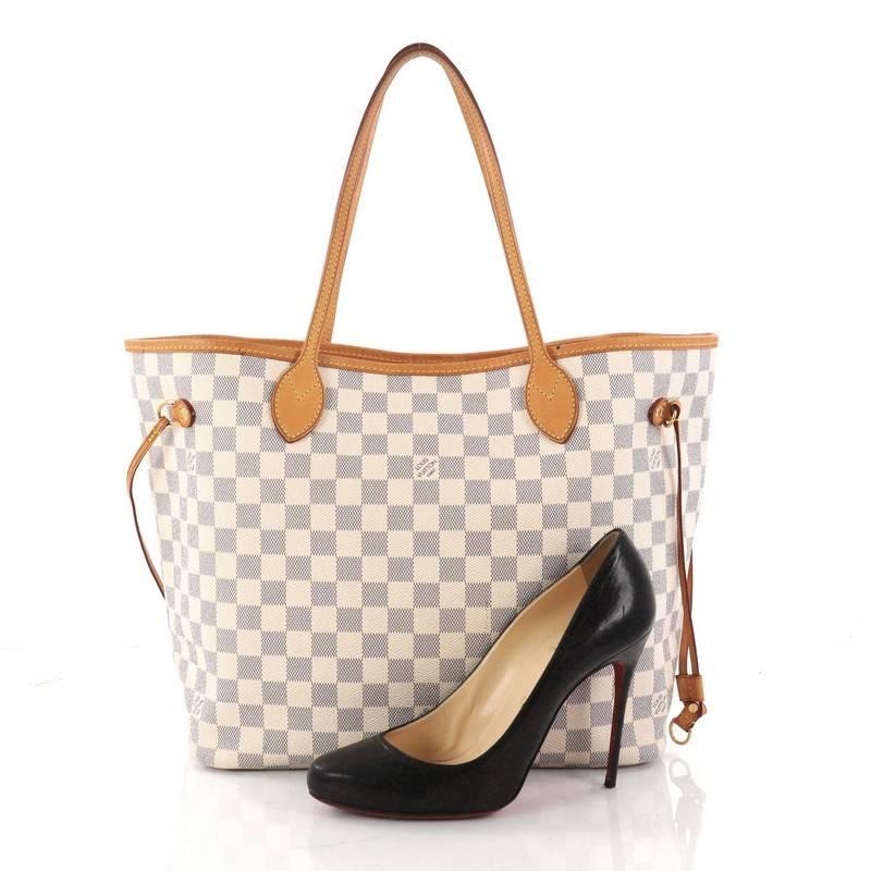 This authentic Louis Vuitton Neverfull Tote Damier MM is a popular and practical oversized tote beloved by many. Constructed with Louis Vuitton's signature damier azur coated canvas, this tote features dual slim vachetta leather handles, side laces