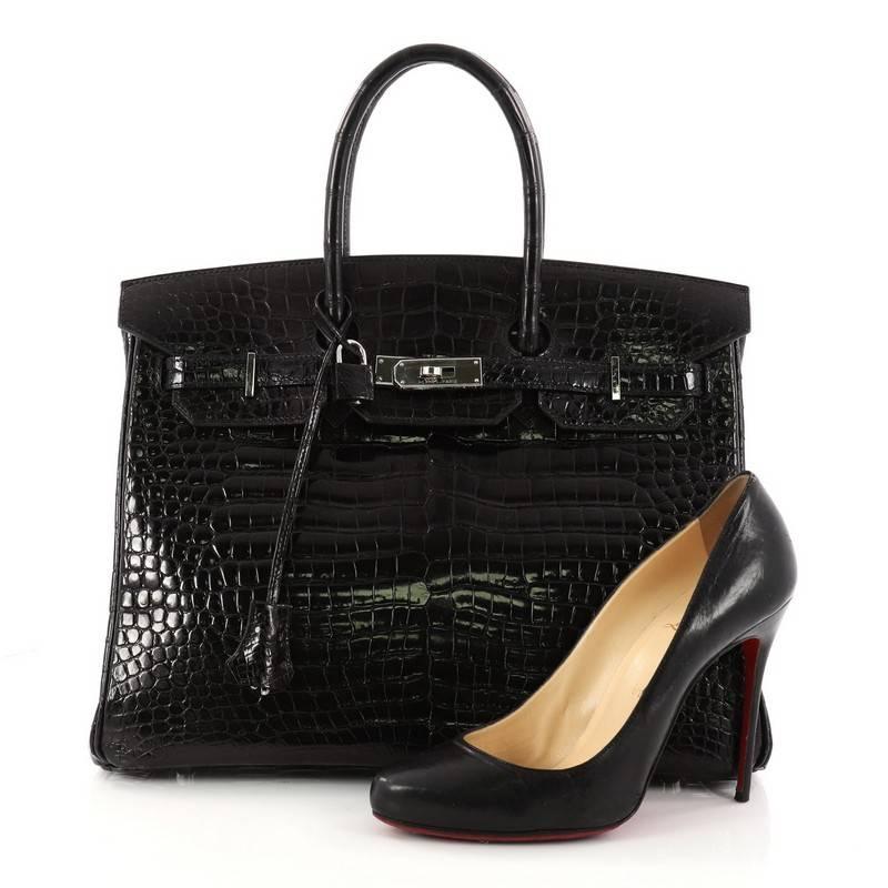 This authentic Hermes Birkin Handbag Black Shiny Porosus Crocodile with Palladium Hardware 35 stands as one of the most-coveted bags fit for any fashionista. Constructed from genuine black shiny porosus crocodile, this stand-out oversized tote